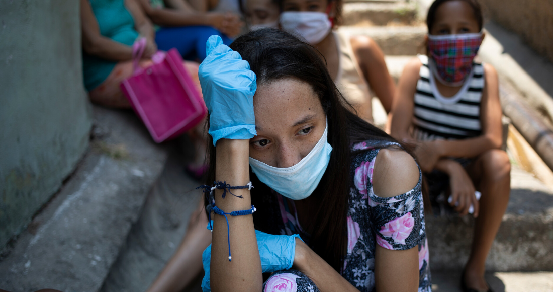 Una mujer, con mascarilla y guantes para protegerse del coronavirus. Foto: Ariana Cubillos, AP